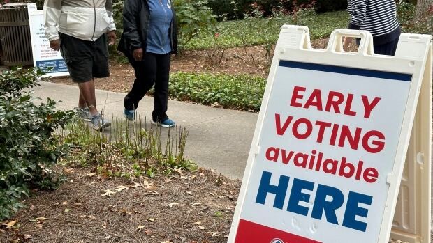 Three individuals are shown, walking in different directions, on a sidewalk near a sign that says 'Early Voting available here.'