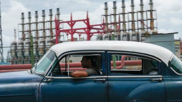 A person drives past a floating generator in Havana on Friday. The generator has not been producing power for several days.