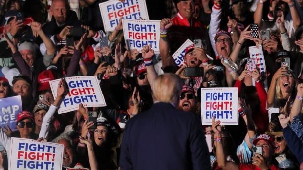 Trump on stage, surrounded by signs that say, "Fight!"