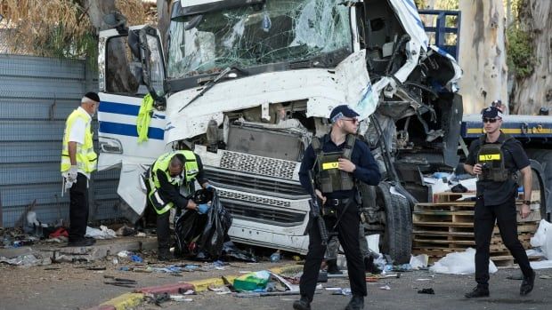 Israeli police and rescue services inspect the site where a truck driver rammed into a bus stop.