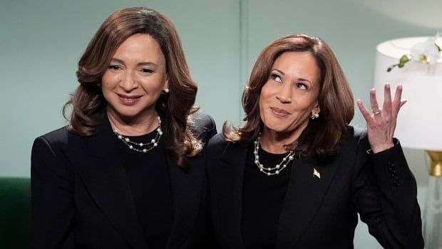 Two women wearing identical black suits appear together on a popular late night TV show.