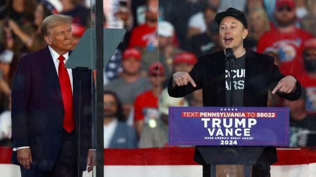 Tesla CEO and X owner Elon Musk is seen speaking as Republican presidential nominee and former U.S. president Donald Trump looks on during a rally in Pennsylvania.