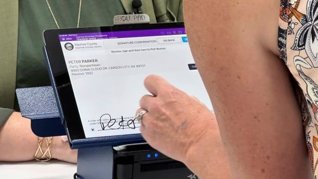 A person signs on electronic pad.