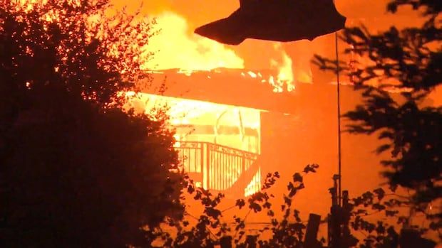 A building is covered in flames in the night.