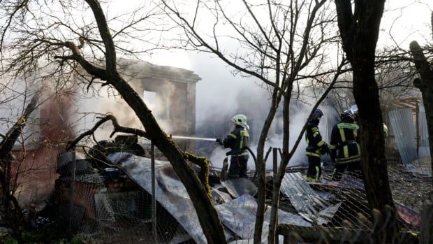 Firefighters work the scene of a drone strike. 