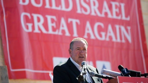 A man in a suit stands at a podium. A red banner behind him says "Build Israel Great Again".