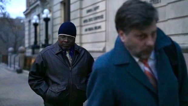 Two men walk outside a courthouse.