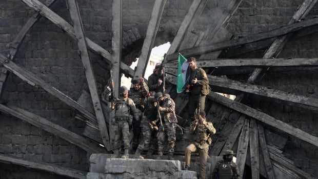 Fighters pose in one of Hama's water wheels.