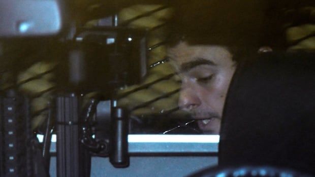 Luigi Mangione is seen inside a police car after leaving an extradition hearing at a courthouse in Hollidaysburg, Pa.