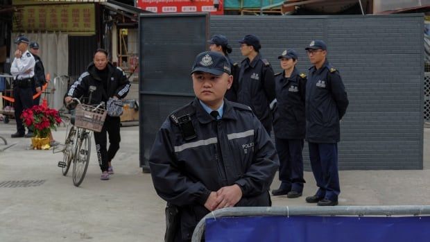 Police and Customs officers stand guard at a checkpoint.