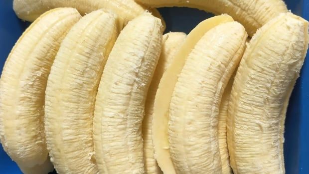 A pile of peeled bananas, some sliced in half