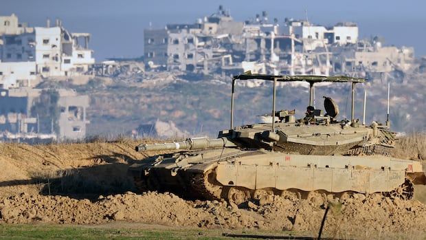 A tank in a field with a town in the background.