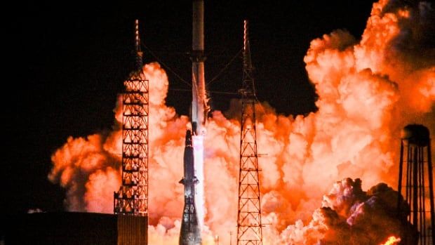 A rocket is seen taking off from a launch pad, as smoke billows.