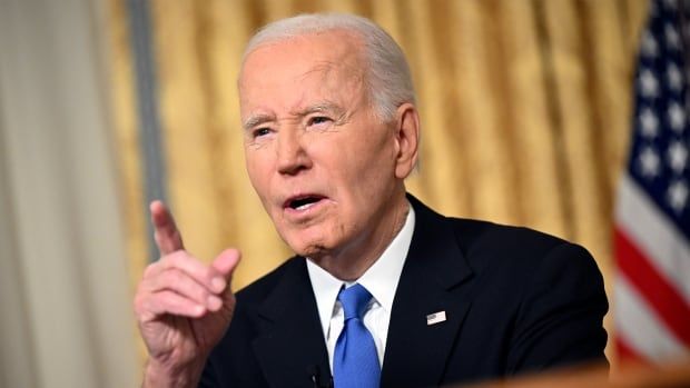 Man in suit points finger while speaking at platform