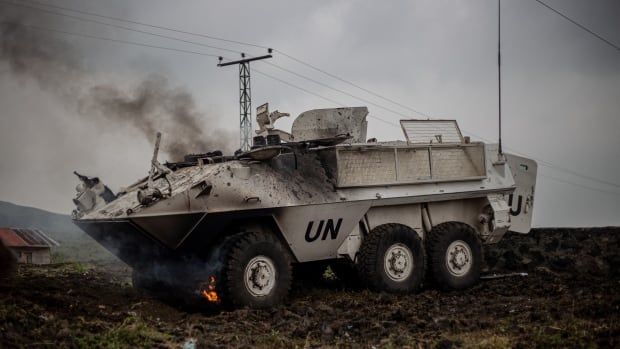 An armoured personnel carrier burns on the side of the road.