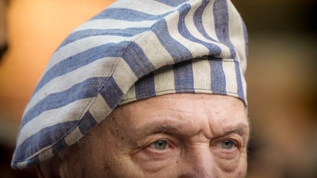 A portrait of an older man in a striped hat. You just  see his  eyes and hat