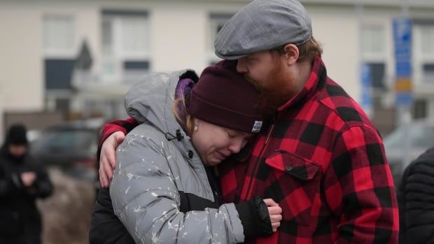 Mourners embrace.