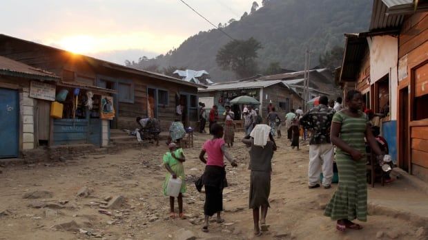 People walk down a road in a village.