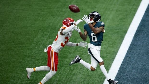 A men's football player catches a pass.