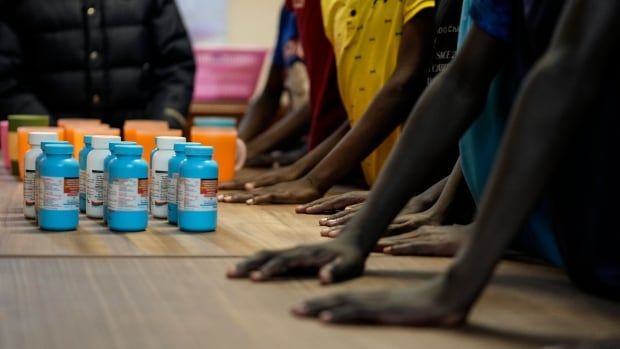 Children's hands reaching for medicine