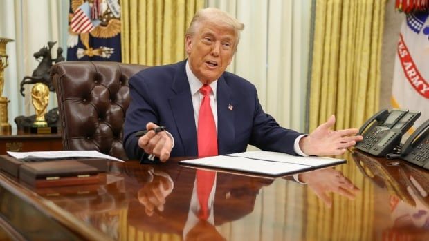 Trump at his desk signing an executive order