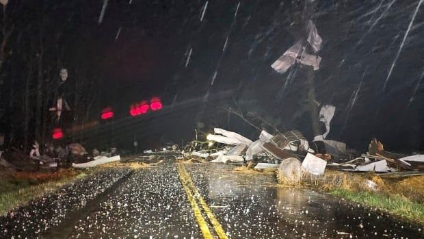 Debris and hail cover a road.