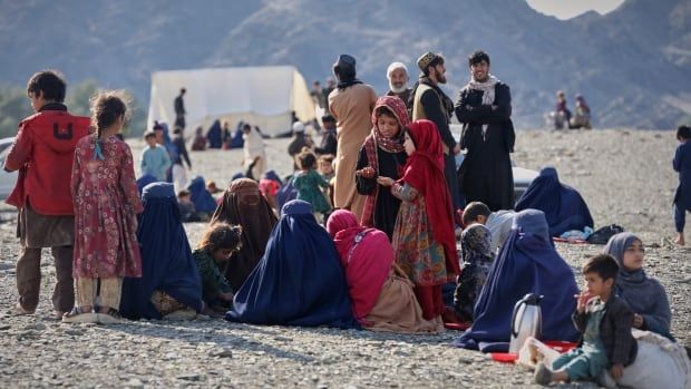 Men, women and children sit along a border.