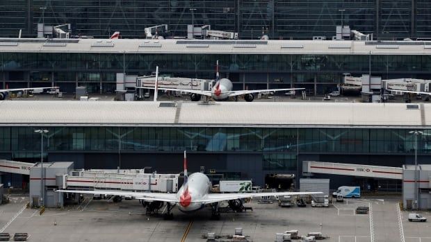 Two parked jets are seen at a large airport.