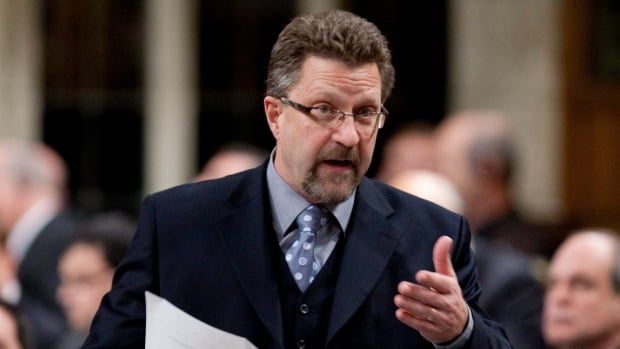 A man in a suit with a beard and glasses