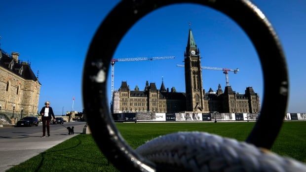 A legislature seen through the ring of a fence on a summer day.