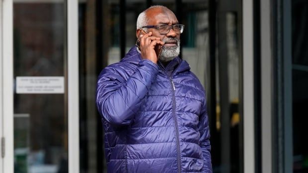 Abousfian Abdelrazik speaks on the phone as he leaves the a building where his case is being heard in Federal court in Ottawa, Wednesday, Oct. 30, 2024. 