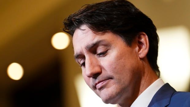 Prime Minister Trudeau looks down as he wears a blue suit