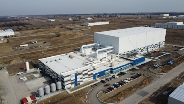 A factory is seen near farm fields.