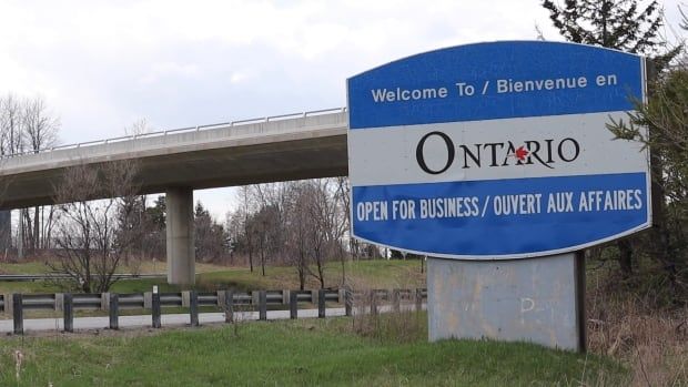 A large sign next to a road says 'Ontario — Open for business'