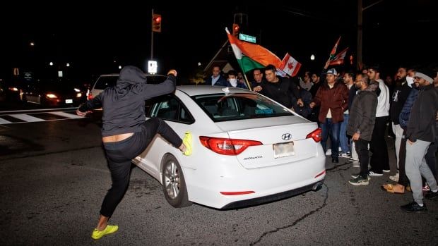 A young person taking part in a march kicks a car after it honked at members of Brampton’s Hindu community, who were blocking traffic, near the Hindu Sabha temple on Nov. 4, 2024.