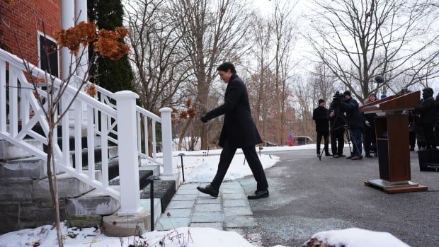 A man walks toward stairs outdoors.