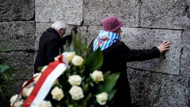 Survivors and relatives putting their hands on the so-called Death Wall during a ceremony at the Auschwitz-Birkenau former Nazi German concentration and extermination camp