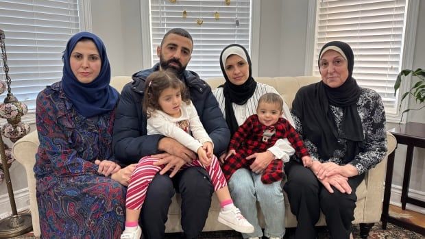 A family sitting on the couch together. 