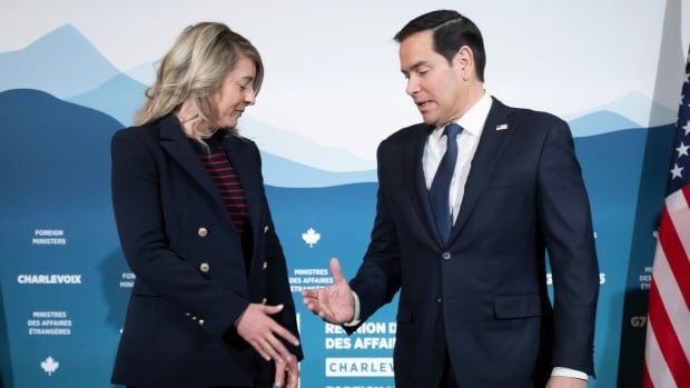 Canadian Foreign Minister Melanie Joly and U.S. Secretary of State Marco Rubio reach out to shake hands at the G7 foreign ministers meeting in La Malbaie, Quebec.