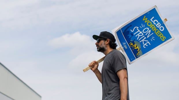 A man holds a picket sign.