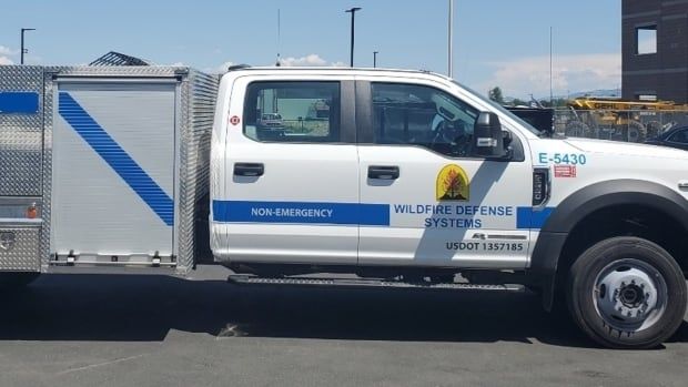 A white truck owned by Wildfire Defense Systems is emblazoned with the company's logo and is marked as "non-emergency."