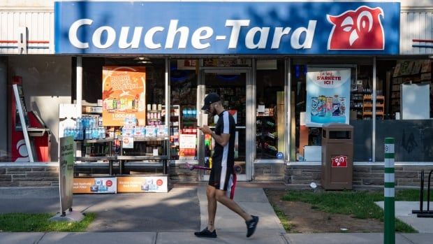 A man walks by a Couche Tard convenience store.