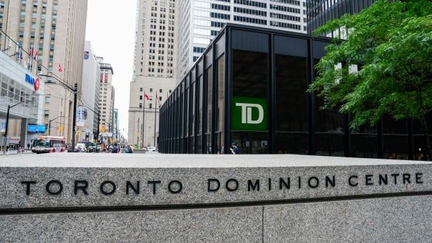 The words "TORONTO DOMINION CENTRE" are shown in black lettering on a polished stone wall with the TD Bank logo visible on a building beyond it. 