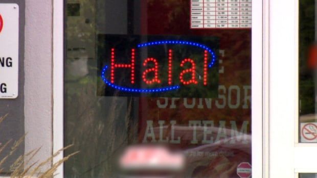 A neon sign saying "Halal" hangs in a window.