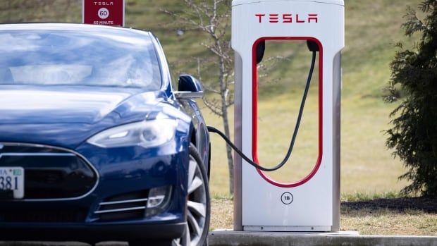 A Tesla Model S vehicle is seen plugged into a charging station in Falls Church, Va.