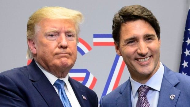 Two men in suits shake hands for the camera