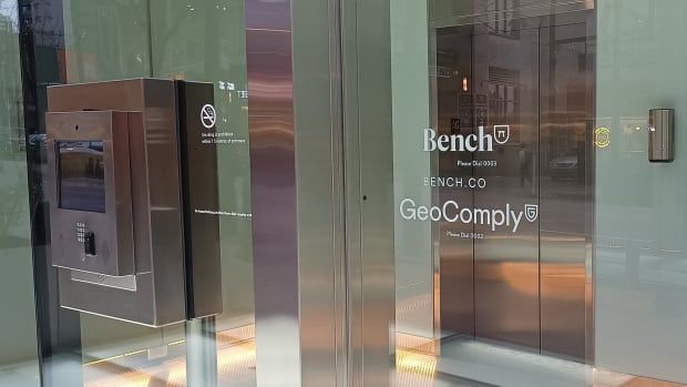 An entrance to a glass office building with the words 'Bench Bench Co. GeoComply.'