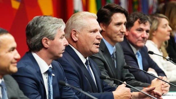 Premier Doug Ford and Prime Minister Justin Trudeau speak into a microphone