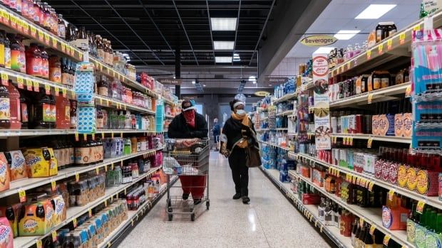 Shoppers browse in a supermarket while wearing masks to help slow the spread of coronavirus disease (COVID-19) in north St. Louis, Missouri.