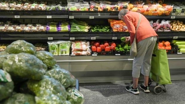 A person is seen shopping for produce.